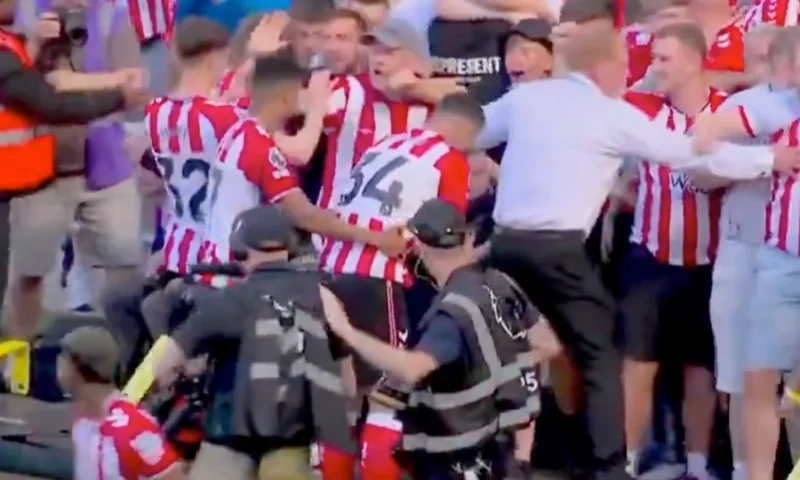 Chaos as Premier League stadium’s advertising board COLLAPSES and security forced to move fans back in stands