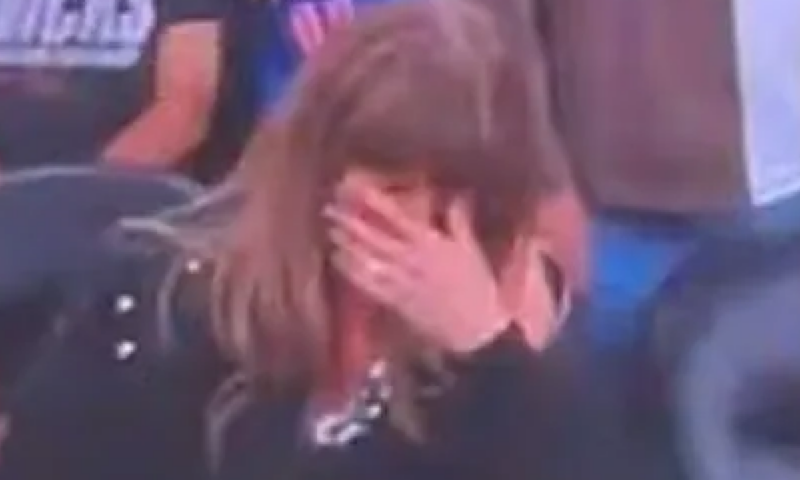 Taylor Swift covers eyes as fiance Travis Kelce downs beer on big screen at NBA game before falling asleep