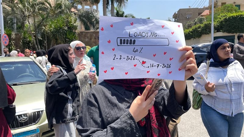 لدعمها بعد الامتحان، فتاة تنتظر شقيقتها بلافتة “loading 40%” أمام لجان الثانوية العامة (فيديو وصور)