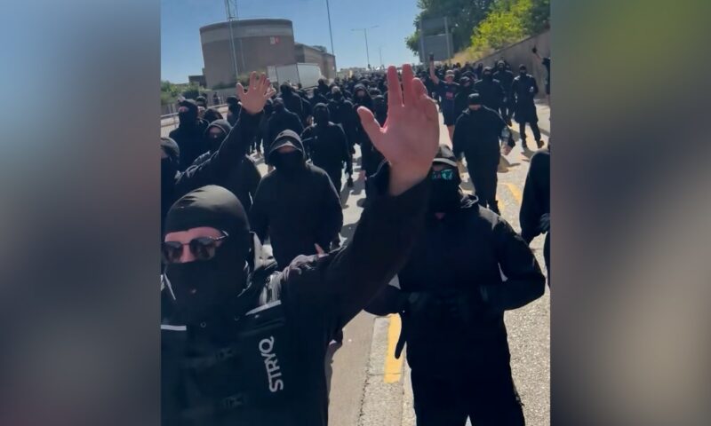 ملثمون يرتدون ملابس سوداء يغلقون الطرق في احتجاج مناهض للهجرة ببريطانيا
