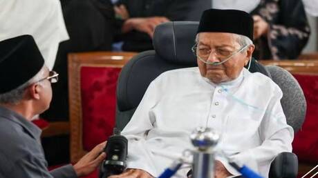 على كرسي متحرك.. مهاتير محمد يودع رفيقة دربه 70 عاما