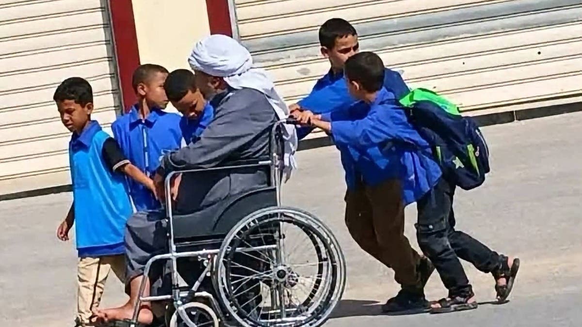 أطفال يساعدون شيخاً مقعداً في الجزائر.. صورة تتصدر “الترند”