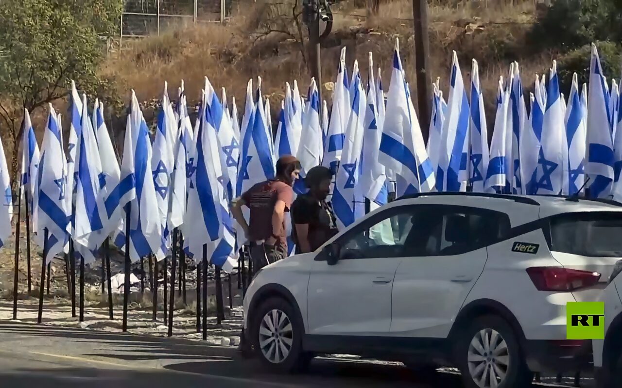 مستوطنون إسرائيليون يضعون أعلاما أمام مقهى فلسطيني في الضفة الغربية